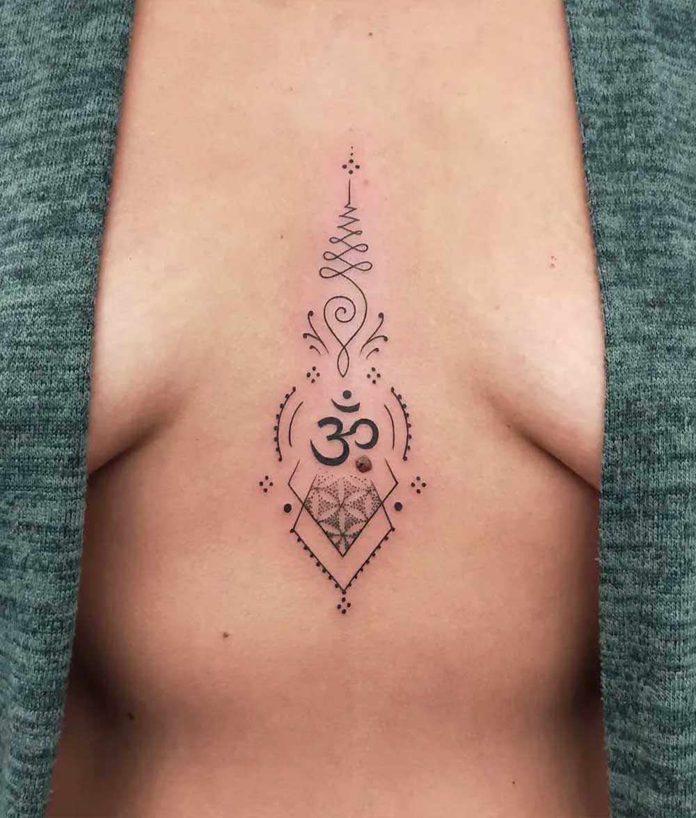 Unalome e Om tatuaggio in mezzo al seno Unalome e Om tatuaggio in mezzo al seno